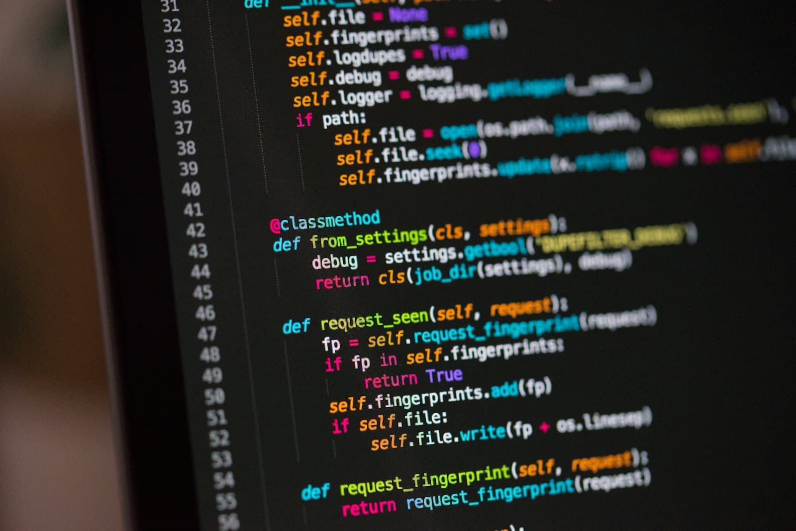 Laptop keyboard with code on the screen behind it
